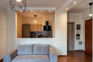 un salon avec un canapé et une cuisine dans l'établissement Luxury apartment overlooking the citadel of Tsakas, à Athènes