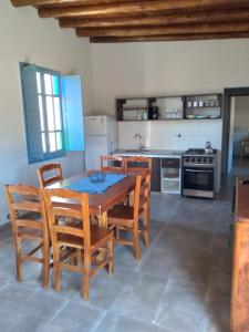 a kitchen with a wooden table and chairs in a room at Finca La Clementina in Tunuyán