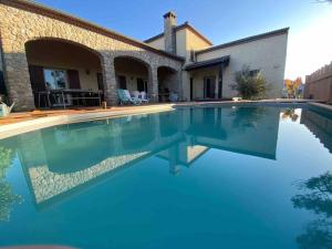 a swimming pool in front of a house at L’échappée de Vallon in Vallon-Pont-dʼArc