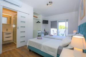 a bedroom with a bed and a table and a balcony at Stella Maris, Hvar - rooms with balcony and stunning sea views in Hvar