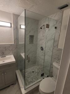 Un baño con ducha, inodoro y lavabo. en New Star Suite Two, en North Miami Beach