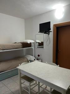 Zimmer mit einem Tisch, einem Bett und einem TV in der Unterkunft Villa Ialillo in Peschici