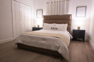 Un dormitorio con una cama grande con dos mesitas de noche. en New Star Suite Two, en North Miami Beach