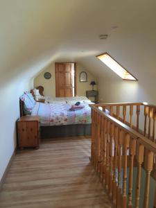 a bedroom with a bed and a wooden staircase at Kate’s Cottage 