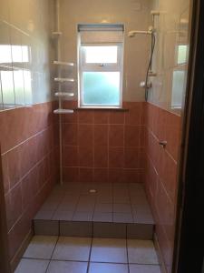 a bathroom with a shower with a window at Kate’s Cottage 