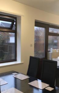 an office with a table and two chairs and windows at Falcon Drive Room 1 in Oldham