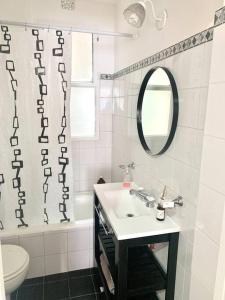 a white bathroom with a sink and a mirror at flat in Buenos Aires in Buenos Aires