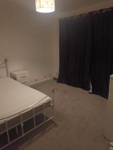 a bedroom with a bed and a black curtain at Falcon Drive Room 1 in Oldham