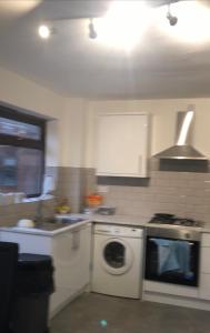 a kitchen with a stove and a washing machine at Falcon Drive Room 1 in Oldham