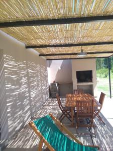 een patio met een tafel en stoelen en een televisie bij Finca La Clementina in Tunuyán