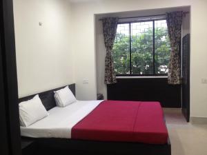 a bedroom with a large bed and a window at Hotel Nest International in Kolkata