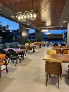 un restaurant avec des tables, des chaises et de nombreuses tables dans l'établissement Trio Resort, à Ulcinj