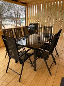 a black dining table and chairs on a wooden floor at Beach House Mane Sol - Perfect Seafront House For Relaxing Holidays in Drage +29 photos