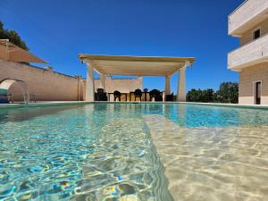 a swimming pool with a gazebo on a house at White Stone in Fasano