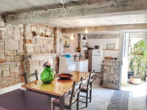 uma cozinha e sala de jantar com uma mesa de madeira e cadeiras em Minimalistic Oasis by the Sea in Stanici em Celina