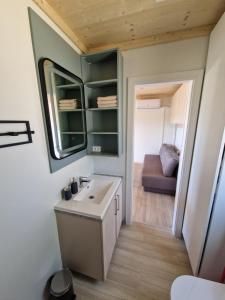 a bathroom with a sink and a mirror and a couch at Beach House Mane Sol - Perfect Seafront House For Relaxing Holidays in Drage