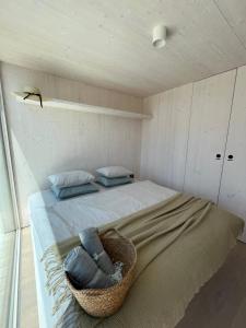 a bedroom with a bed with a basket on it at BUQEZ ECO RESORT - Beach Villas 2 and 8 - Seaview, new wifi! in Drage