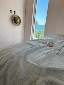 a baby doll laying on a bed with a window at BUQEZ ECO RESORT - Beach Villas 2 and 8 - Seaview, new wifi! in Drage