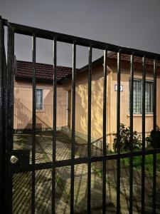 a view of a house through a gate at Casa con Jacuzzi in San Pedro de la Paz