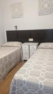 a bedroom with two twin beds and a dresser at Arran de Mar Cambrils in Cambrils