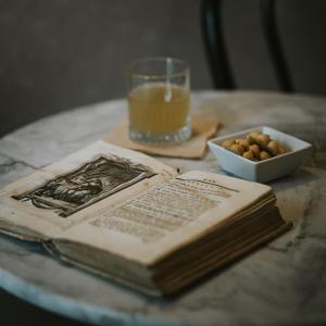 een open boek op tafel met een glas sinaasappelsap en noten bij B&B Locanda della Vittoria in Catania +77 foto's