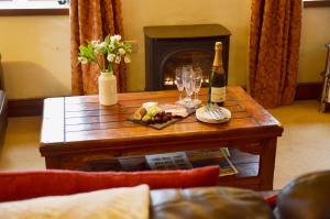 een tafel met een fles wijn en glazen erop bij Chestnut in Alston