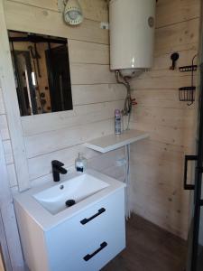 a bathroom with a white sink and a mirror at Domki na zaciszu w Rynie in Ryn