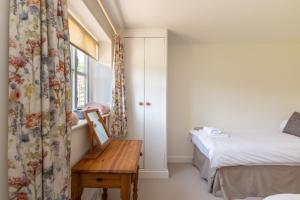 a bedroom with a bed and a table and a window at The Dairy in Beaminster