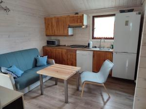 a kitchen with a couch and a table in a room at Domki na zaciszu w Rynie in Ryn