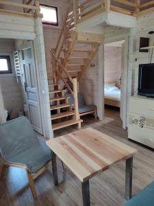 a room with a staircase and a table and a couch at Domki na zaciszu w Rynie in Ryn