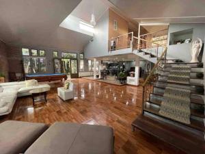 una gran sala de estar con suelo de madera y una escalera. en La casa de luz en Concepción de Ataco