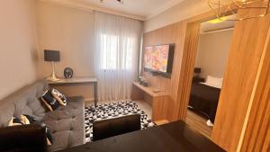 ein Wohnzimmer mit einem Sofa und einem Bett in der Unterkunft Flat Ninety Jardins próximo Pq do Ibirapuera - SP in São Paulo