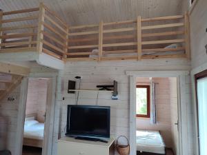 a room with a tv and a bunk bed at Domki na zaciszu w Rynie in Ryn