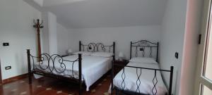 two beds in a bedroom with white walls at Casa Barone in Roccadaspide +233 photos