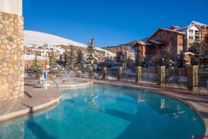 een zwembad in een resort met een berg op de achtergrond bij NEW Listing Perfect Location 414 with Heated Pool and Hot Tub in Crested Butte