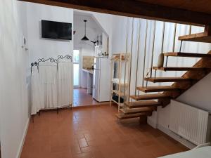 a room with a staircase and a kitchen with a refrigerator at Casa Doros in Eforie Sud