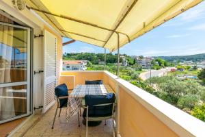 a patio with a table and chairs on a balcony at Apartments Marija I in Lopar
