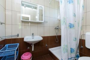 a bathroom with a sink and a toilet and a shower curtain at Apartments Marija I in Lopar