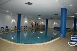 a swimming pool with blue chairs and a swimming pool at Aktea Beach Village in Ayia Napa