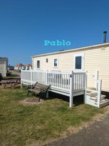 a building with a porch and a bench next to it at 2 Bedroom 6 berth Caravan Towyn Rhyl in Rhyl