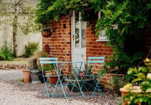2 Stühle und ein Tisch vor einem Haus in der Unterkunft The Coach House Barn in Shrewsbury + 18 Fotos