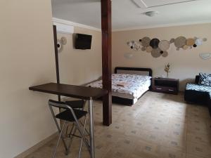een slaapkamer met een bed, een tafel en een spiegel bij Apampa Apartman in Hajdúszoboszló