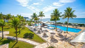 an aerial view of a resort with a pool and the ocean at Itapema Beach Hotel & Convention in Itapema
