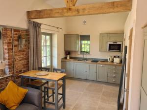 a kitchen with a table and a dining room at Dragonfly cottage in Christchurch