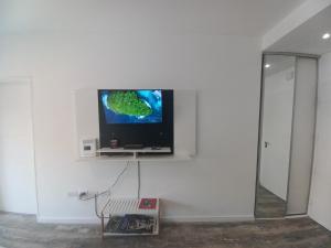 a flat screen tv on a white wall in a room at @juanbjustoapartamento in Buenos Aires