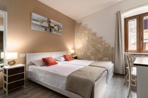 una camera con due letti e un muro di pietra di Casa Albina a Rovigno (Rovinj)