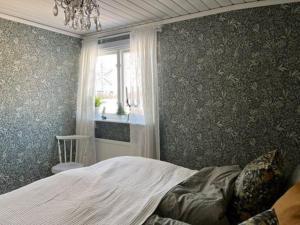 a bedroom with a large bed and a window at Sommarstuga med sjötomt och brygga in Hedemora