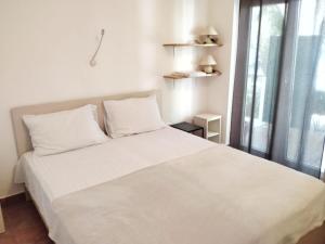 Minimalistic Oasis by the Sea in Stanici في سيلينا: سرير أبيض في غرفة بها نافذة