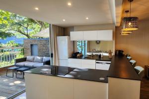 a kitchen with a counter top and a living room at Pacific Suite in Arue