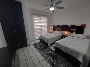 Villas Cozumel #10 في كوزوميل: غرفة نوم بها سريرين ومروحة سقف +10 صور